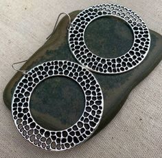 Here are some unique, chic and fun big circle earrings.  They are simple yet refined.  They have a cool textured design which gives them a rustic modern look.  Versatile and perfect for everyday wear.The earrings measure 1 7/8” long by 1 7/8” wide.  They hang from simple silver ear wire hooks.  Overall drop length is 2”.  Made from allergy free plated silver.I have a matching necklace in my shop if you would like the whole set.  Here is a direct link............. https://etsy.me/3cg1X6cThanks fo Big Circle Earrings, Hoop Earrings Large, Ocean Earrings, Boho Hoop Earrings, Geometric Hoop Earrings, Round Dangle Earrings, Statement Hoop Earrings, Earrings Big, Hammered Earrings