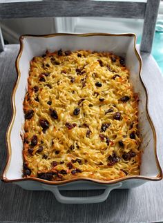 a casserole dish with cheese and raisins in it sitting on a chair