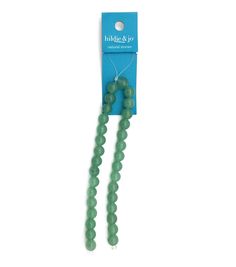 two green beads are packaged in a package