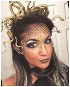 a woman wearing gold and black makeup with snakes on her head