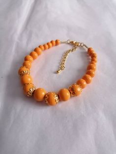 Beaded bracelet with orange wooden beads and gold Accents Throughout. Bright Jewelry, Clean Sterling Silver, Wooden Jewellery, Orange Bracelet, Orange And Gold, Statement Bracelet, Wooden Jewelry, Wooden Beads, Gold Accents