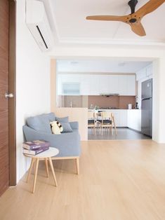 a living room filled with furniture and a ceiling fan in the middle of an open floor plan