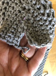 a hand holding a crocheted object in it's palm