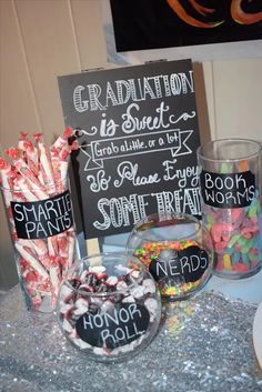 a table topped with lots of candy and candies next to a chalkboard sign