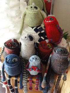 a group of stuffed animals sitting on top of a wooden table