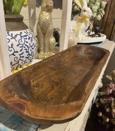 a wooden bowl sitting on top of a table next to vases and other decorative items