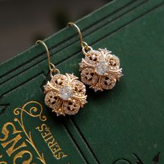 Beautifully sparkly 18k gold plated dangle and drop earrings in a Regency / Victorian style with perfectly shaped round faceted cubic zirconia stones. The drops measure 1.5cm (0.6") in length. Perfect wear for any occasion or to give as a special, thoughtful gift. Your earrings will arrive to you in gift box ready to give or to treat yourself. These earrings are perfect for a bride or bridesmaids for a classic or vintage themed wedding. If you would like a larger quantity, please DM us or email 1930 Jewelry, Victorian Gold Earrings, Regency Jewelry, Earrings Zirconia, Art Nouveau Earrings, Art Nouveau Earring, Victorian Earrings, Gold Dangle Earrings, Diamond Dangle Earrings