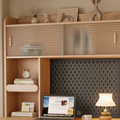 a laptop computer sitting on top of a desk next to a lamp and bookshelf