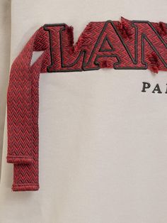 the back of a white shirt with red and black letters that spell out paris on it