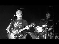 two men are playing guitars on stage