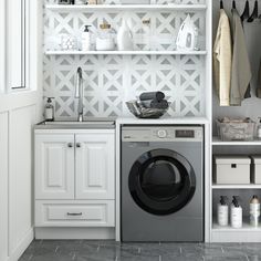 a washer and dryer in a white laundry room with open shelving on the wall