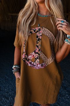 Effortlessly boho - chic, the Ebbie Peace Sign Tunic is the perfect dress for any occasion! You're going to find yourself always wanting to wear this dress! Comfortable Cotton tee shirt fabric Relaxed and loose tee shirt dress silhouette Classic round neckline and loose short sleeves So cute contrast floral peace sign center front patch Convenient side seam pockets Exposed seam with raw edges throughout for added boho style Pair: Eye Of The Sun Padded Bralette, Frenchie Raw Edge Shorts and Turqu Bohemian Printed Boho Dress With Short Sleeves, Bohemian Boho Dress With Printed Short Sleeves, Bohemian Boho Dress With Short Sleeves And Print, Spring Festival Hippie T-shirt, Bohemian Boho Dress With Short Sleeves, Casual Floral Print Boho Dress For Festivals, Casual Boho Dress With Floral Print For Festival, Casual Flowy Boho Dress With Short Sleeves, Flowy Short Sleeve Boho Dress In Casual Style