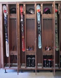 several skis and snowboards are lined up in the locker for storage on display