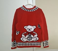 This listing is for a handmade Teddy Bear sweater for newborn babies, toddlers, infants and young kids. Each sweater is 100% knitted by hand and has a beautiful teddy bear design in black, white and red. This jumper can be personalized with initials or names and it can also be customized in terms of its color, pattern, design, measurements, shape, size, material and thickness since I typically purchase new material for each order. You can even choose to have the sweater crocheted instead of knitted.  This adorable sweater is perfect to wear out and keep warm in fall and winter or to gift your loved ones for any special occasion. It is made with 100% acrylic yarn, so I recommend that you machine wash it on gentle cycle or hand wash it with warm water and a gentle detergent. For hand wash, l Cute Red Winter Sweater, Red Knitted Acrylic Sweater, Red Acrylic Knitted Sweater, Casual Hand Knitted Red Sweater, Cute Red Crew Neck Sweater, Casual Red Hand Knitted Sweater, Cozy Red Acrylic Sweater, Playful Long Sleeve Red Sweater, Red Hand Knitted Crew Neck Sweater