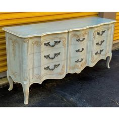 an old dresser is painted white and gold