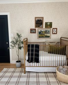 a baby crib in the corner of a room with pictures on the wall