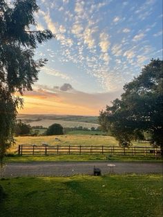 the sun is setting over an open field