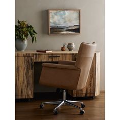 a brown office chair sitting in front of a wooden desk with a potted plant on it