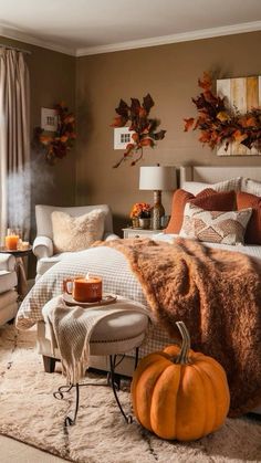 a bedroom decorated for fall with pumpkins and candles