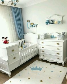 a baby's room with white furniture and blue curtains