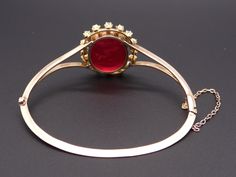 Jewelry Type: Bracelet Metal: 14k Yellow Gold Measurements: Length: 7 inch Top: 30mm x 25mm Markings: None ( scratch & acid tested) Weight: 17.2 grams Center: Oval Cut Venetian Glass w carved Intaglio Color: Red Measurements: 23mm x 18mm Accent Stones: 8 matching Rose Cut Diamonds Color: H Clarity: SI-1 Weight: 0.40cts total approx Accent Stones: 8 matching Round Pearls Color: White Measurements: 2.5mm #12219 Gold Intaglio Jewelry For Evening, Yellow Gold Cabochon Bracelets For Weddings, Diamond Intaglio Jewelry, Round Diamond Intaglio Jewelry, Evening Diamond Bracelet, Luxury Screw Back Wedding Jewelry, Formal Rose Cut Diamond Bangle, Formal Intaglio Bangle Jewelry, Bracelet Metal