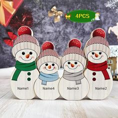 four wooden snowmen with hats and scarfs