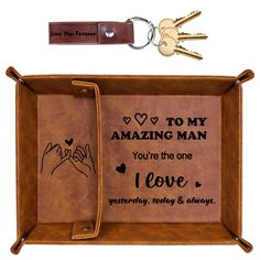 a leather key holder with two keys attached to it and the words, to my amazing man you're the one i love