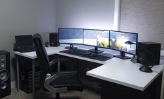 a computer desk with two monitors and speakers