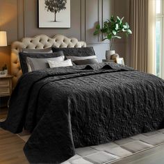 a bed with black comforter and pillows in a room