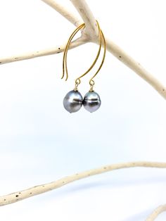 This is a simple, classic earring with a beautiful pair of Tahitian pearls. No two Tahitian pearls are alike, so matching them into pairs is a challenging task. In addition to the shape, the color tone of the pearl's surface varies in each one because they are naturally colored, non-died pearls. The hook-shaped ear wire is made of vermeil and about 1.5 inches/ 4 cm in length. There is a shorter hook version of this style available as well in the listings. Total length : 2 inches / 5 cm Tahitian Classic Tahitian Pearl Earrings As Gift, Classic Tahitian Pearl Earrings For Gift, Tahitian Pearl Dangle Earrings Gift, Classic Tahitian Pearl Jewelry With Matching Earrings, Classic Tahitian Pearl Drop Jewelry, Tahitian Pearl Drop Earrings, Tahitian Pearl Drop Earrings Gift, Classic Gold Tahitian Pearl Earrings, Gold Tahitian Pearl Earrings Gift