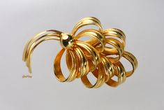 "Beautiful, dimensionally curved flower brooch pin in gleaming gold tone, unsigned. Pin measures approximately 2 3/4\" x 1 5/8\". It weighs 0.8 oz. The brooch is 'like a brand new' in mint condition. Possibly late 50s or early 60s. It is a vintage item in very good condition. We combine shipping, If you want to take advantage of the reduced shipping you must contact us before you pay for your items so we can send you a corrected invoice. Thank You for visiting our Etsy store https://www.etsy.com Designer Brooch, Trifari Brooch, Early 60s, Trifari Jewelry, Mid Century Jewelry, Crystal Bangle, Pearl Brooch, Gold Flower, Rhinestone Bracelet