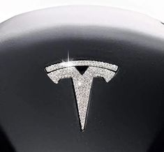 the tesla logo is shown on this black and white car's steering wheel cover