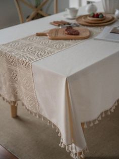 the table is covered with white linens and doily