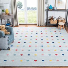 a child's room with a blue chair and rug on the floor, two teddy bears sitting in an armchair