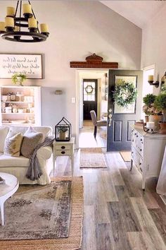 a living room filled with lots of furniture and decor on top of a hard wood floor