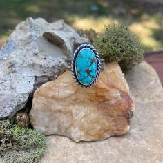 An oval shaped #8 turquoise stone is wrapped in fine silver and surrounded by a tightly twisted silver rope. This stone I would describe as a teal blue with beautiful matrix.  The head of this ring measures 1/2" wide x 3/4" long. Please see photos for size reference.  The ring band is made of sterling silver and has a plain and smooth center with textured edges.  Size: 7-1/2 * This ring cannot be resized  All photos are taken in natural outdoor lighting conditions. Please contact me with questions or for additional photos Untreated Adjustable Oval Turquoise Ring, Artisan Oval Turquoise Ring, Adjustable Oval Turquoise Western Ring, Adjustable Oval Western Style Turquoise Ring, Adjustable Oval Turquoise Ring With Large Stone, Southwestern Adjustable Oval Turquoise Ring, Handmade Adjustable Oval Turquoise Ring, Ring Band, Turquoise Stone