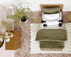 an overhead view of a bed with white and green sheets, pillows and blankets on it