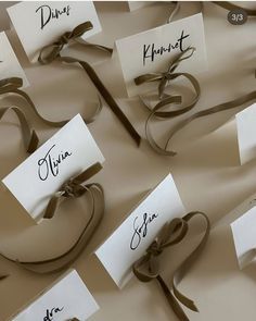 there are many place cards with ribbons on them