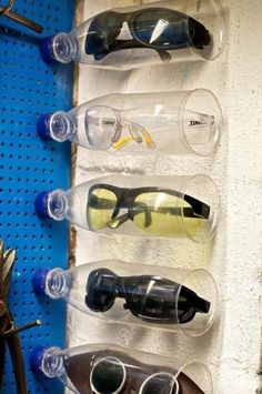 several pairs of sunglasses are lined up on a wall with holes in the middle to hold them