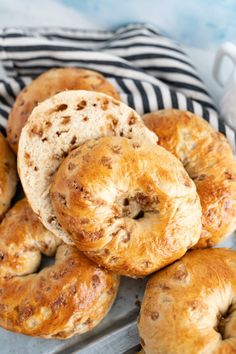 freshly baked bagels sitting on top of a metal tray next to a black and white towel