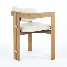 a wooden chair with white leather upholstered seat and back rests against a white background