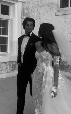 a man in a tuxedo standing next to a woman in a wedding dress