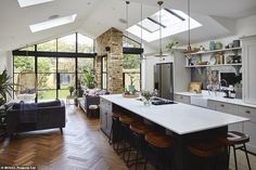 an open concept kitchen and living room with skylights