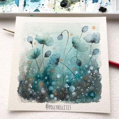 some watercolors are being used to create an art project with blue and green flowers