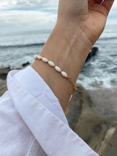 White beaded detailed met with gold accents. The perfect bracelet to match the Lily Necklace or wear on its own! Stack with our other gold pieces or colorful summer beads! Product Details Length: 6 1/2" plus 2" extension Gold Beaded Chain Trendy Bracelets, Adjustable Handmade White Gold Bracelet, Gold Beaded Charm Bracelet For Beach, White Beaded Chain Bracelets, 14k Gold Filled Beaded Bracelets With Tiny Beads, Trendy Gold Beaded Chain Bracelet, Trendy White Bracelets With Beaded Chain, Adjustable Rosary Bracelet With Colorful Beads, Trendy White Beaded Chain Bracelets