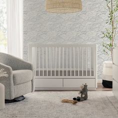 a baby's room with a crib, chair and rug