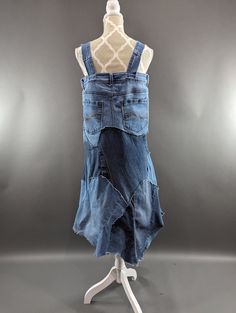 a mannequin wearing a denim dress made from old jeans on a white stand