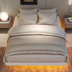 the bed is made with white linens and pillows, along with a night light