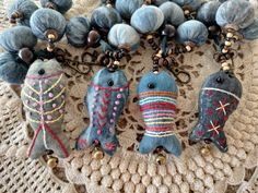 three blue birds are sitting on a doily next to some beads and other items