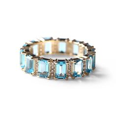 Gorgeous Blue Topaz Emerald Cut Eternity Band with diamond detailing, set in 14K gold. These rings are substantial on their own or for extra wow factor stack with other colors! (This ring may be custom ordered in many other colors, pink sapphire, pink tourmaline, blue sapphire, yellow citrine, green emerald, red ruby. Prices will vary). Topaz is the birthstone for the month of November and is known to exude calming energies while symbolizing love, affection, and strength while deepening one's se Blue Topaz Diamond Ring, Aquamarine Sapphire Ring, Eternity Band Stack, Emerald Cut Eternity Band, Love Affection, Diamond Tennis Necklace, Sense Of Self, Diamond Choker, Mini Charm